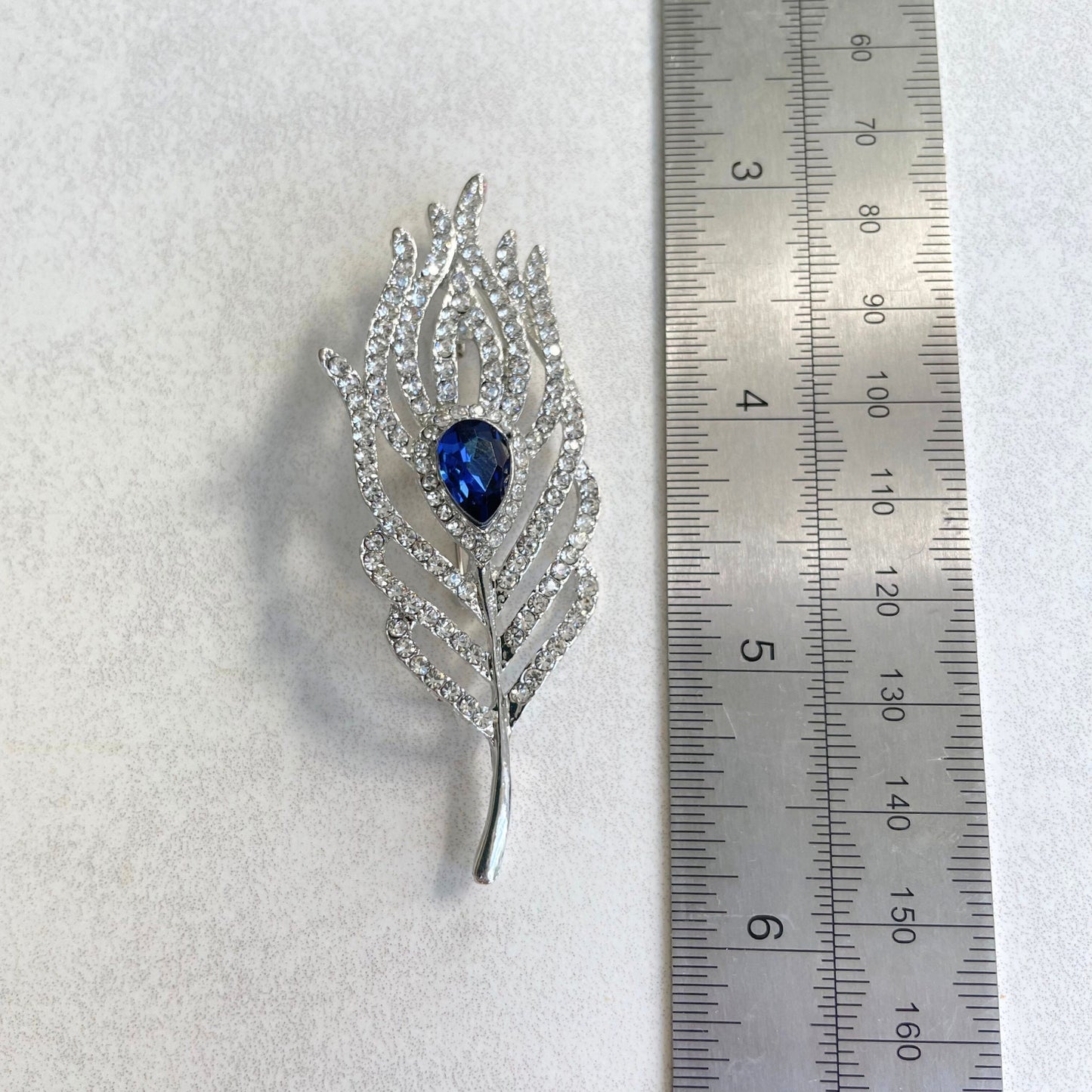 Delicate blue sapphire feather silver pin brooch